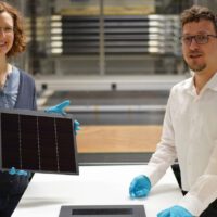 © Fraunhofer ISE / Foto: Jacob Forster Projektleiterin Dr. Laura Stevens zeigt eines der III-V-Germanium-PV-Module mit einer Rekordeffizienz von 34,2 Prozent. Leonhard Böck ist Projektmitarbeiter und hat maßgeblich am – vor ihm liegenden – III-V-Silizium-PV-Modul mit 31,3 Prozent Effizienz mitgearbeitet.