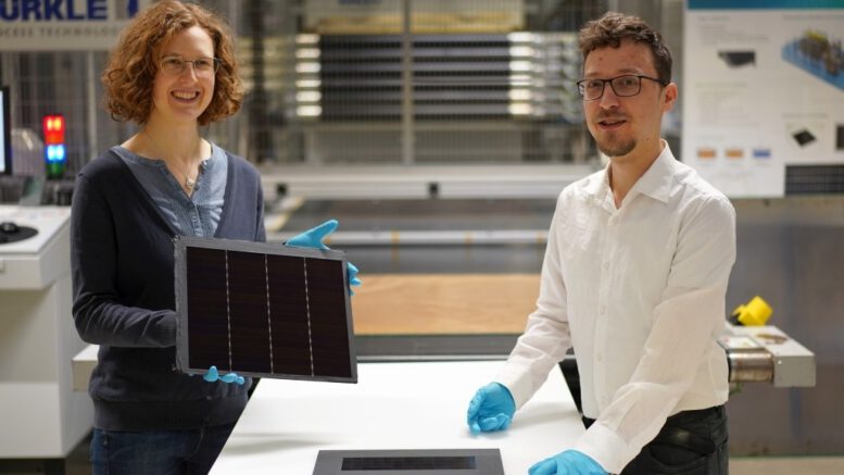© Fraunhofer ISE / Foto: Jacob ForsterProjektleiterin Dr. Laura Stevens zeigt eines der III-V-Germanium-PV-Module mit einer Rekordeffizienz von 34,2 Prozent. Leonhard Böck ist Projektmitarbeiter und hat maßgeblich am – vor ihm liegenden – III-V-Silizium-PV-Modul mit 31,3 Prozent Effizienz mitgearbeitet.